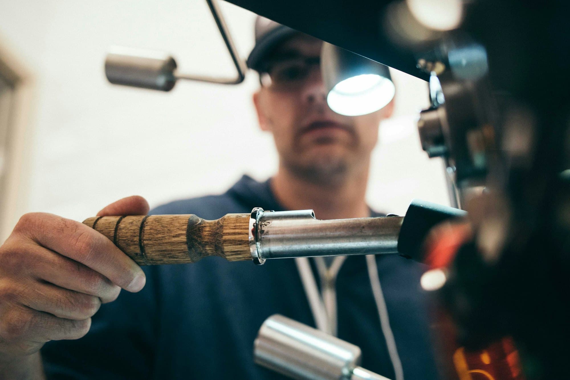 Vakmanhand met precisie-instrument onder een atelierlamp.